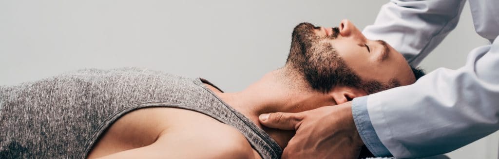 chiropractor performing neck adjustment on patient